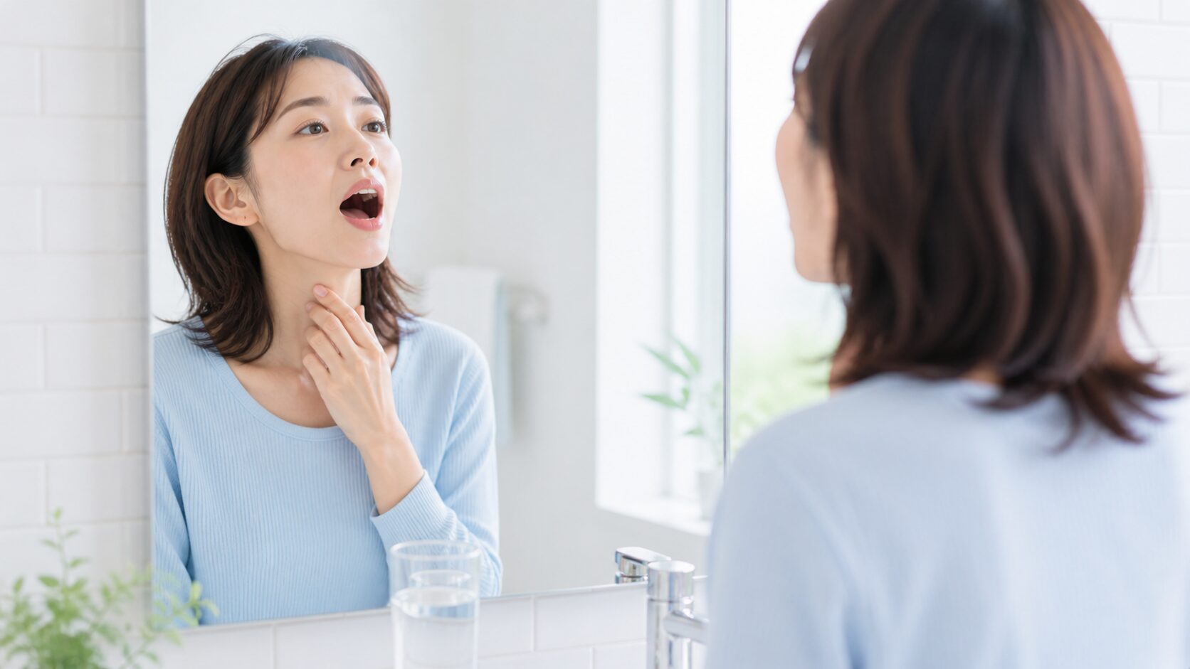 鏡の前で喉のセルフチェックをする女性｜臭い玉の違和感に早めに気づく