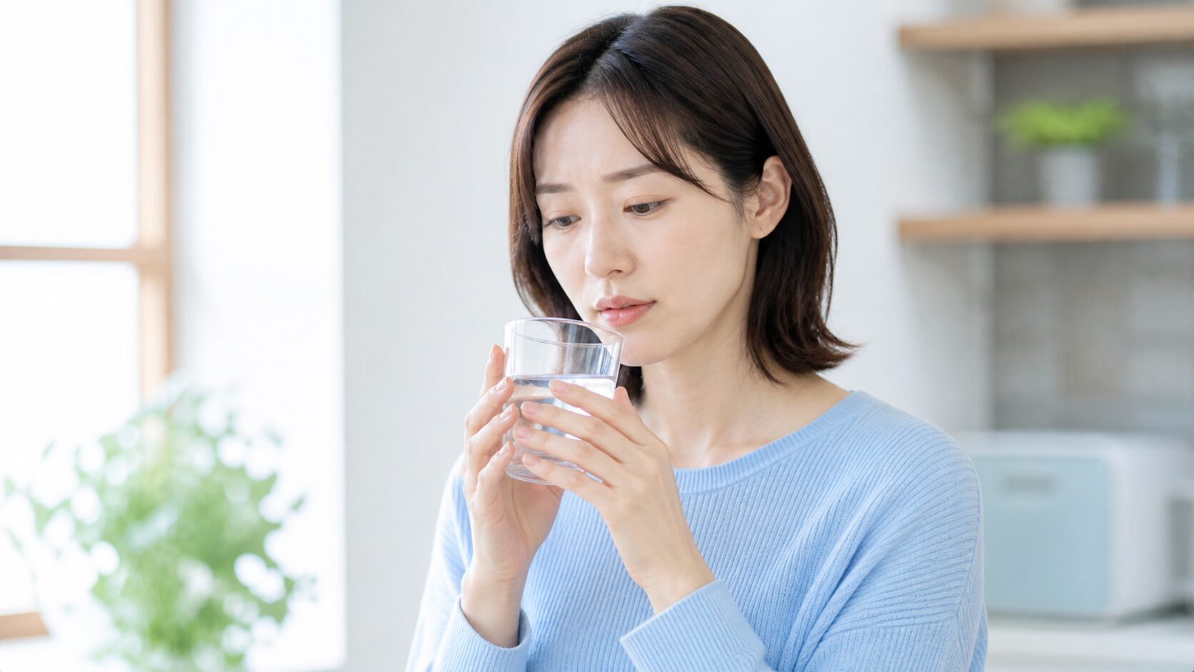 水を飲もうとして口の渇きを感じる女性|ドライマウスの自覚をセルフチェック