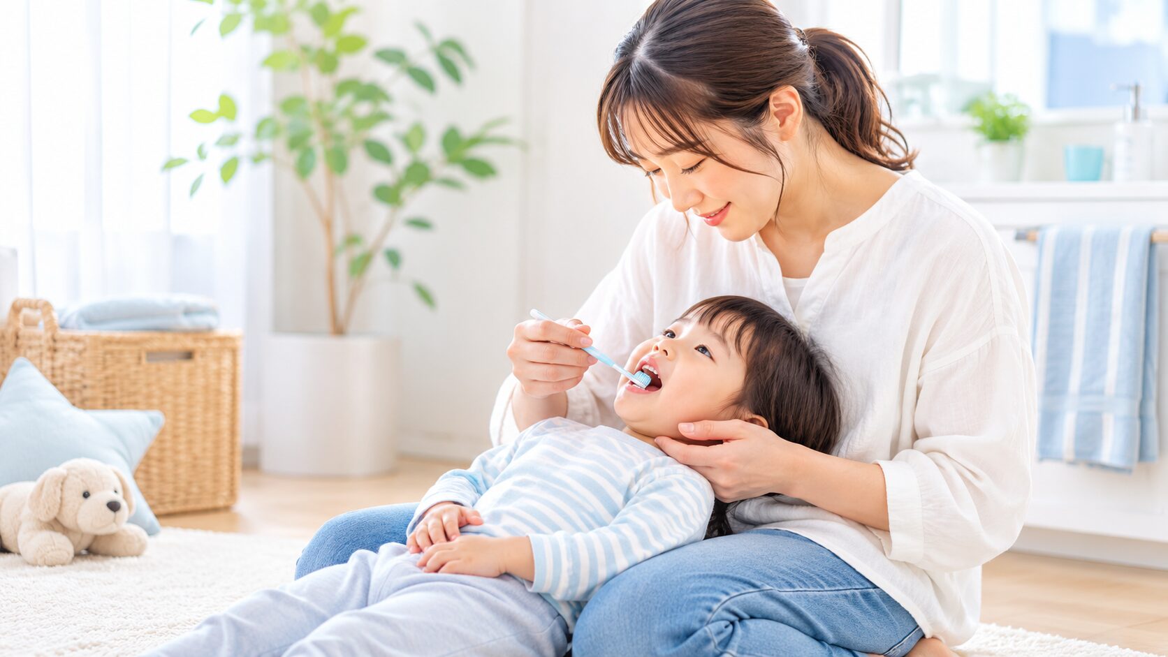 子供の仕上げ磨きをする保護者｜ひざに寝かせて歯みがきする親子
