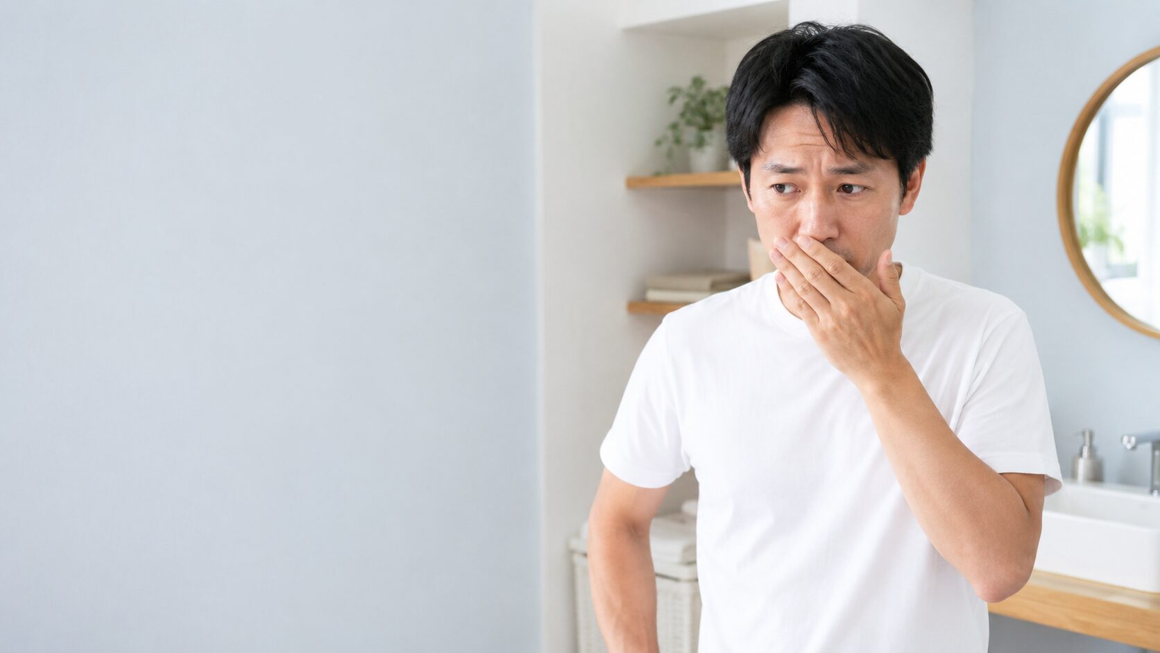 口臭が気になり口元を手で覆う男性｜毎日の歯みがきで口臭ケアを始める