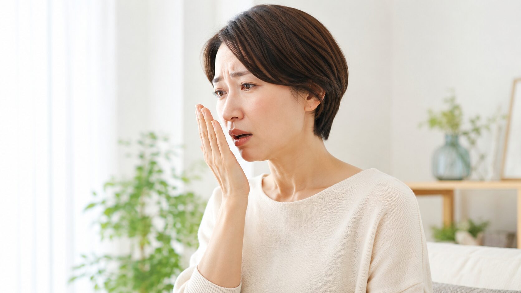 口臭のセルフチェックをする女性のイメージ｜手で覆って自分の息を確認する